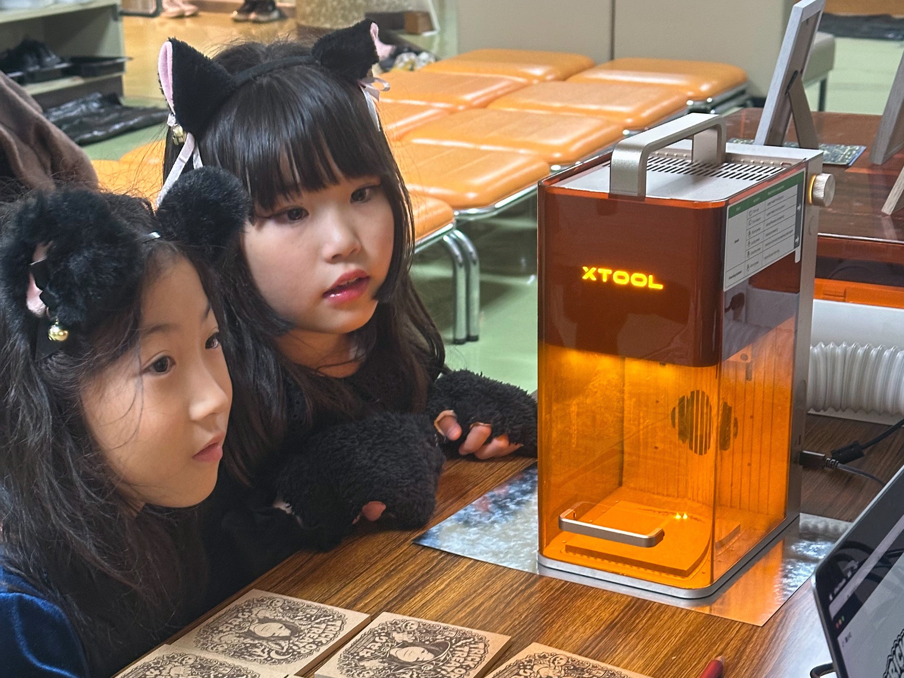 ちとせキッズハロウィンの会場でレーザー加工機を見学する子どもたち